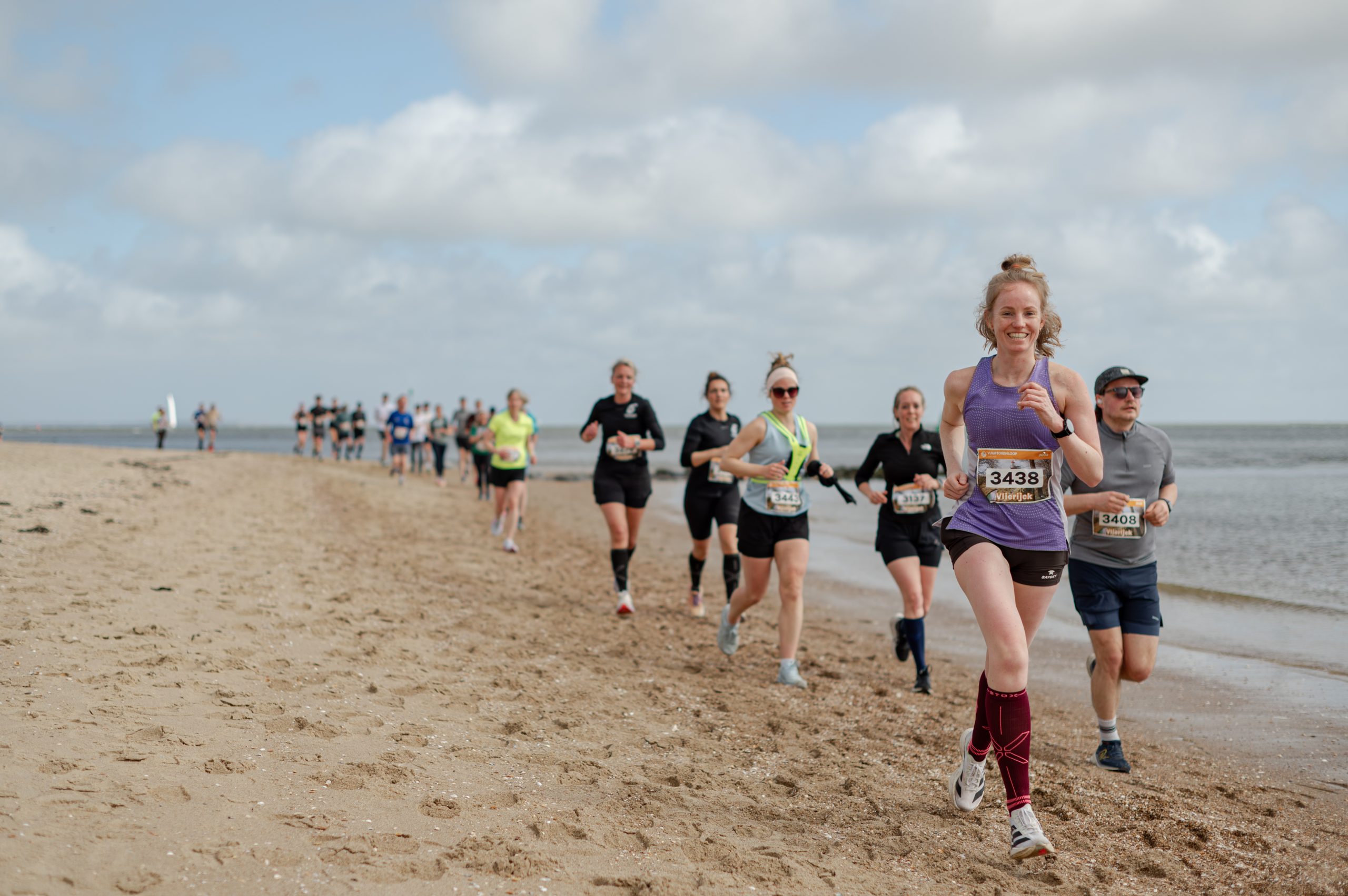 Deelnemers lopen over het strand van Vlieland
