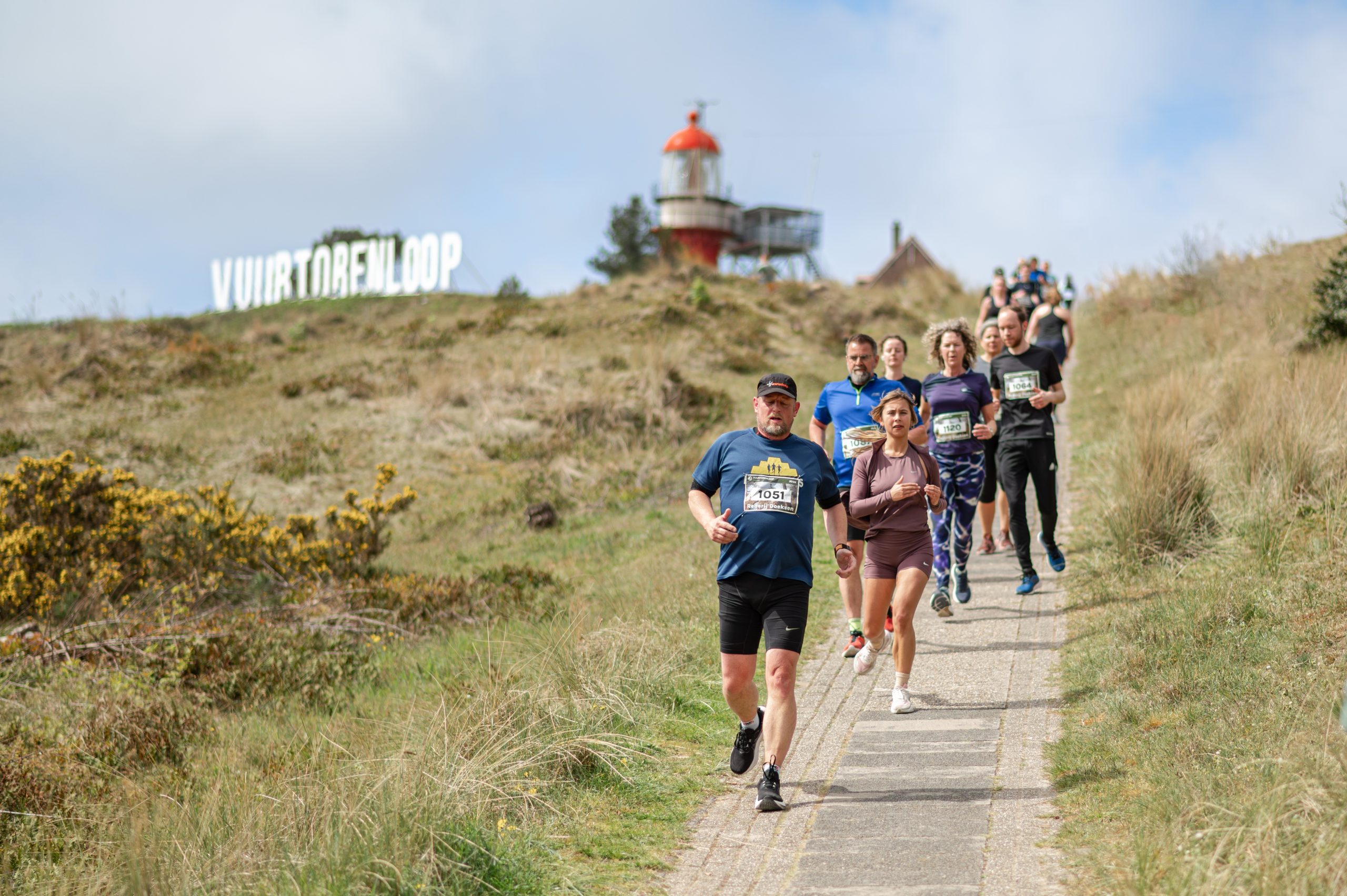 Hardlopers passeren de vuurtoren van Vlieland